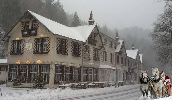 Das Hotel Königreich Romkerhall im Winter. Schneelandschaft im Oberharz mit Pferdeschlitten und Weihnachtsmann
